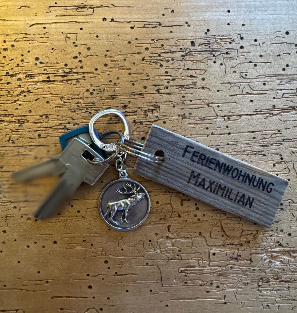 schlüsssel ferienwohnung maximilisn mit schlüsselanhänger auf massivholztischplatte