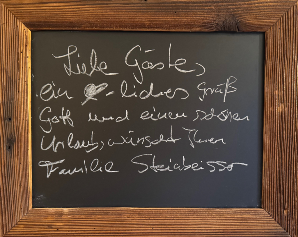 Holztafel mit Aufschrift Willkommen bei Familie Steinbeisser - Ferienwohnungen am Tegernsee
